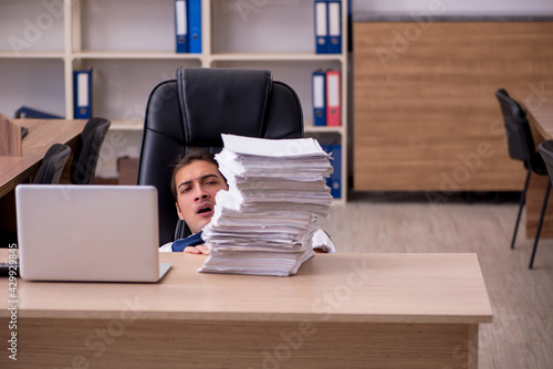 Young male employee unhappy with excessive work in the office