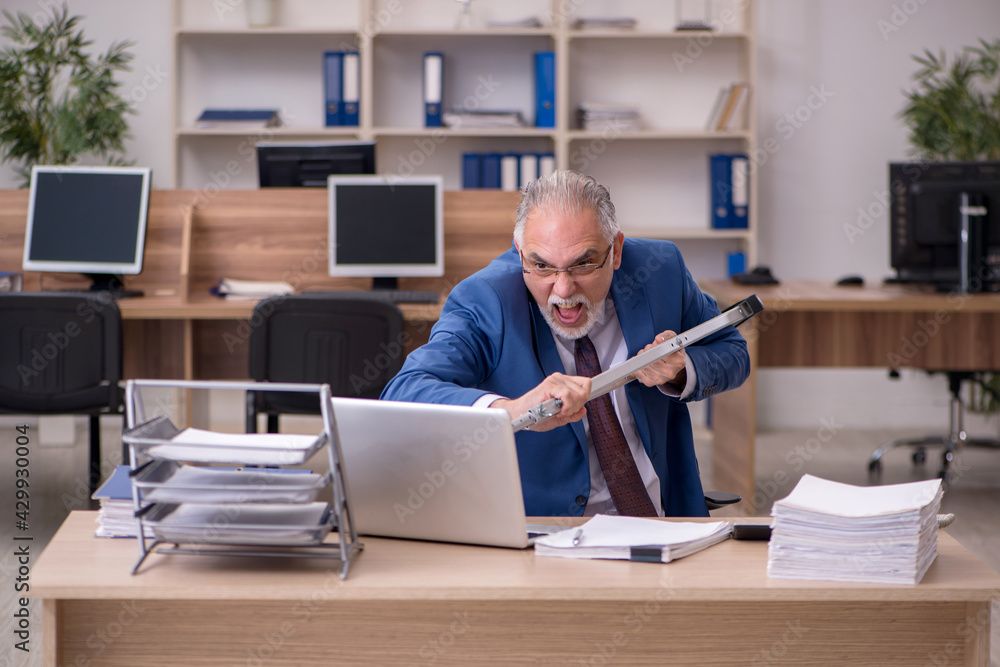 Old businessman employee after accident working in the office Old businessman employee after accident working in the office