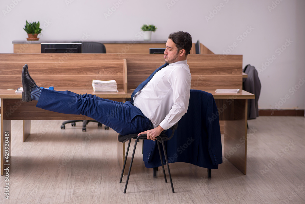 Young businessman employee doing sport exercises at workplace Young businessman employee doing sport exercises at workplace