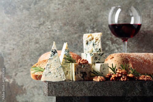 Blue cheese and red wine on an old stone table.