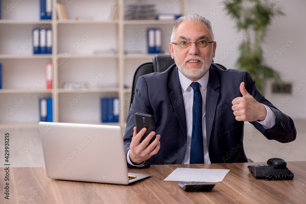 Old male employee working in the office Old male employee working in the office