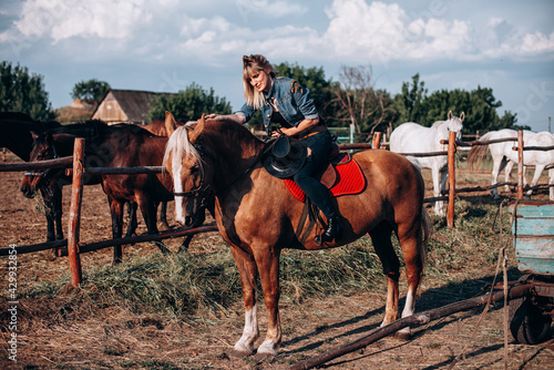 Young woman riding a horse in countryside on rancho © VlaDee