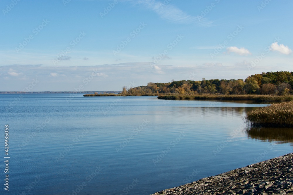 Lake Turawa in Poland at autumn with calm water on a sunny day with blue sky and some clouds Lake Turawa in Poland at autumn with calm water on a sunny day with blue sky and some clouds