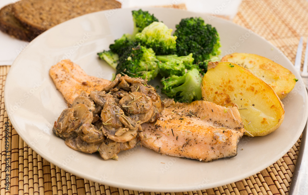 fried river trout fillet with a complex side dish of broccoli, baked potatoes and mushroom sauce fried river trout fillet with a complex side dish of broccoli, baked potatoes and mushroom sauce