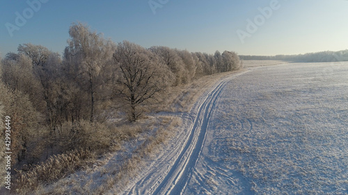 aerial view winter landscape snow covered field and trees in countryside. winter road in countryside. Snow covered farmland and trees during winter