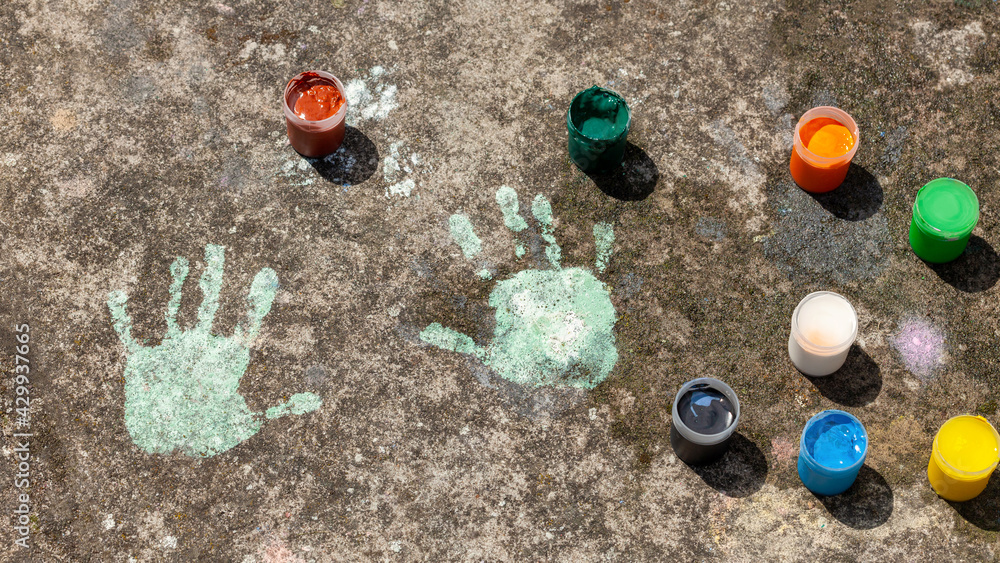 Sensoru Hand Print Child's handprints on the concrete and colorful paint containers ...