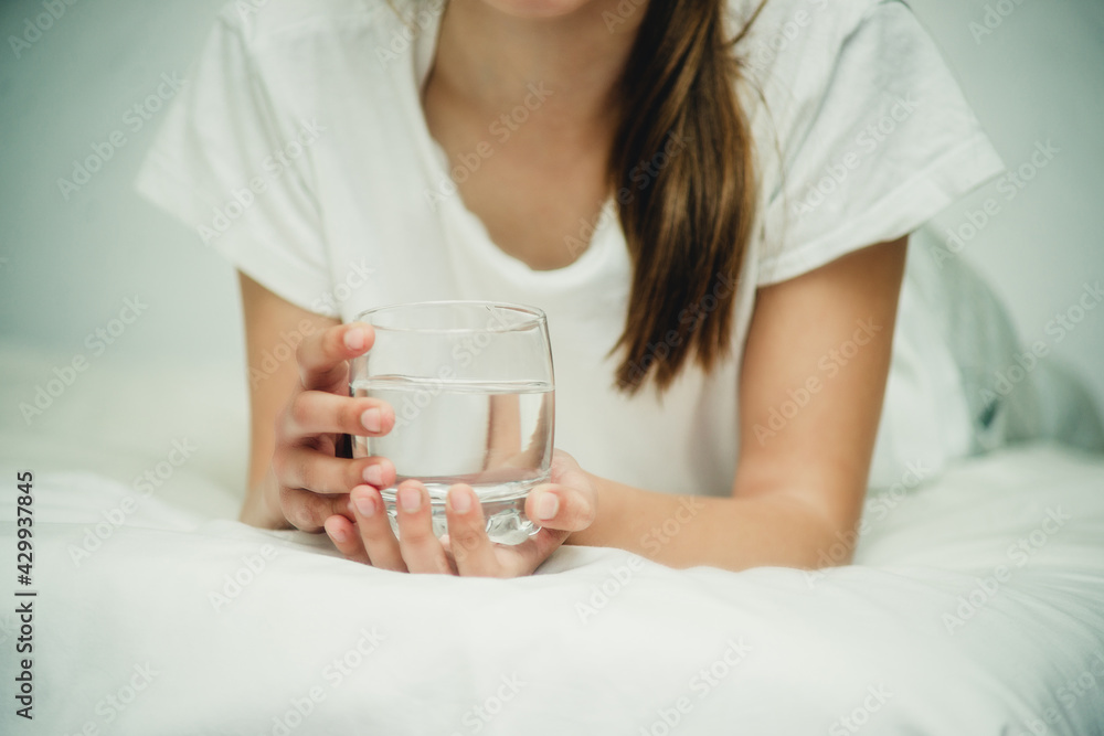 girl with a glass of water on the bed girl with a glass of water on the bed