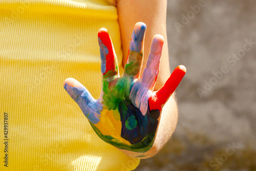 Colorful child's hand, child showing single colored palm of hand covered in paint to the camera, creativity, arts and crafts, art therapy, fun craft activities for kids abstract concept, closeup photo