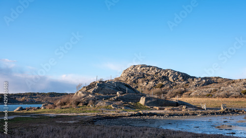 Countryside landscape with road, meadows and stone fences and granite hills in the background. Shot in Sweden, Scandinavia at Säby Kile natural reserve