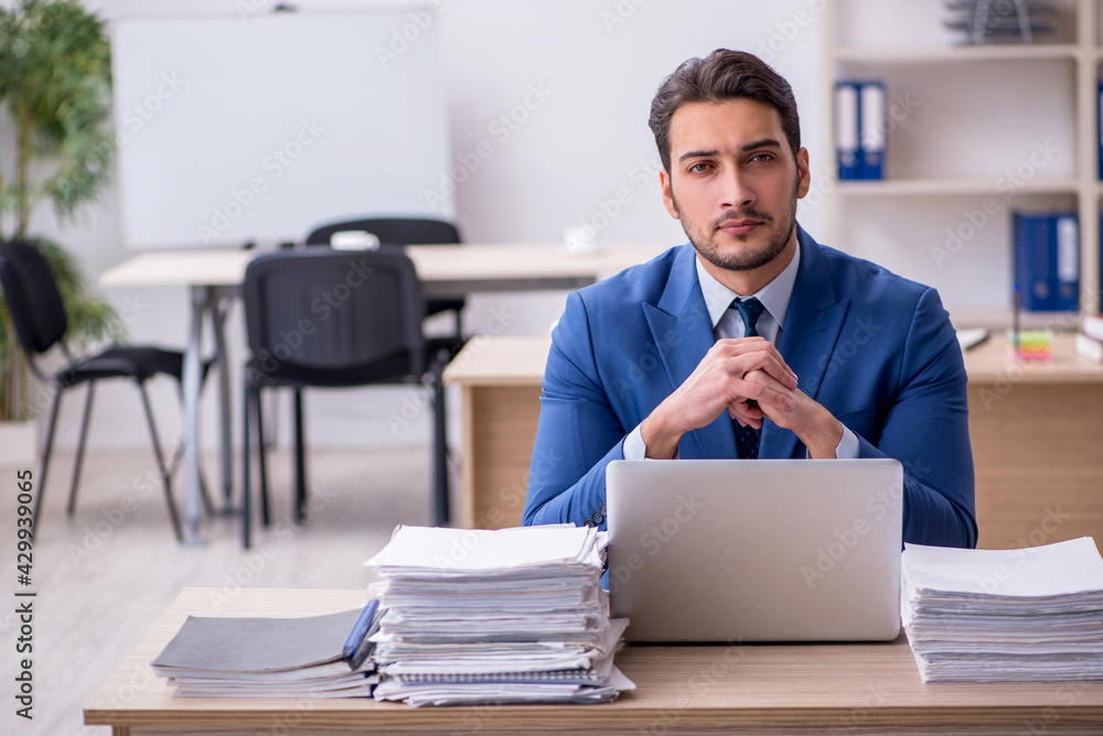Young businessman employee and too much work in the office
