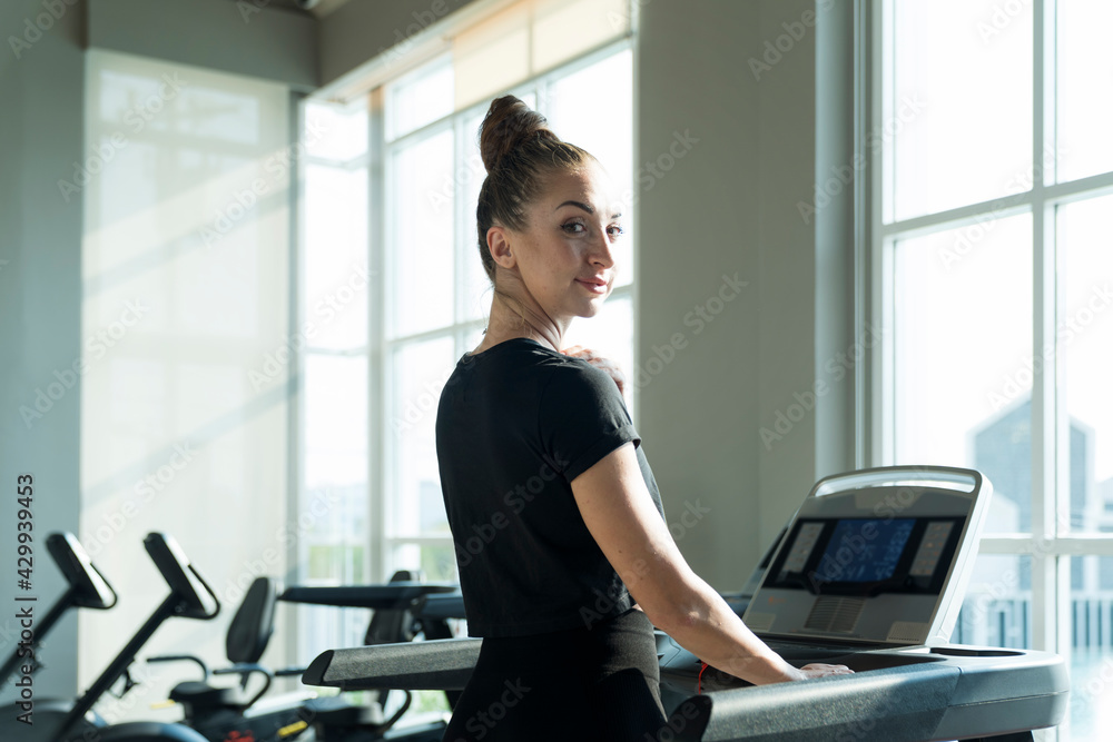  Fit women doing cardio workout and running on treadmill in sport club.