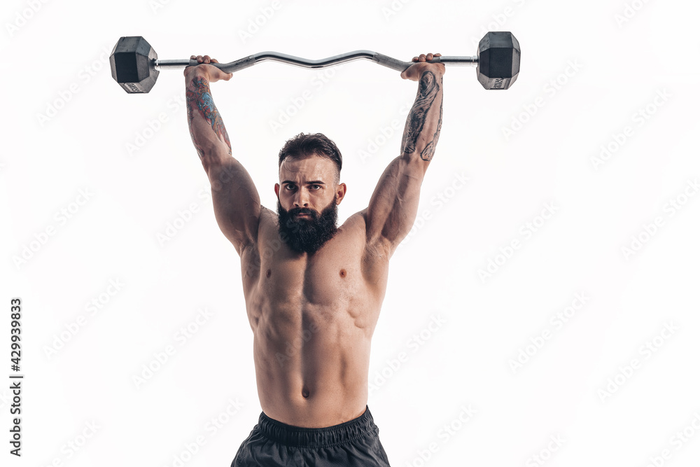 Muscular bodybuilder guy doing exercises with dumbbell over whit Muscular bodybuilder guy doing exercises with dumbbell over whit