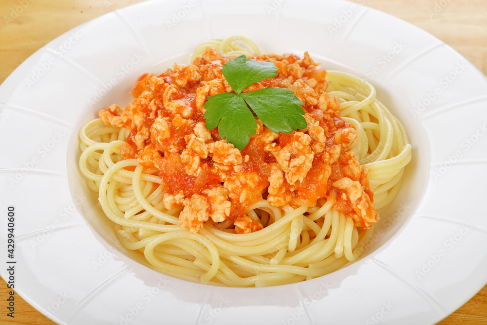 Spaghetti pasta in tomato sauce with chicken on wood background. Spaghetti pasta in tomato sauce with chicken on wood background.