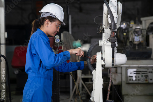 Woman mechanic repairing a robot machine.