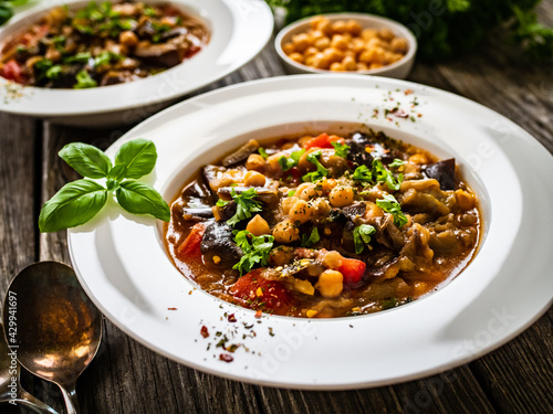 Delicious stew - aubergine with tomatoes and chickpeas on wooden table 