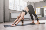 Woman doing yoga in sport studio, stretching her body
