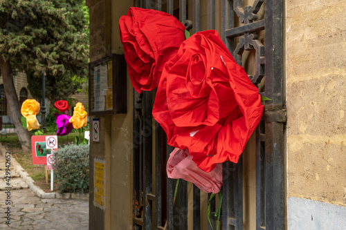 Close-up of paper roses hung on an urban metal door photo