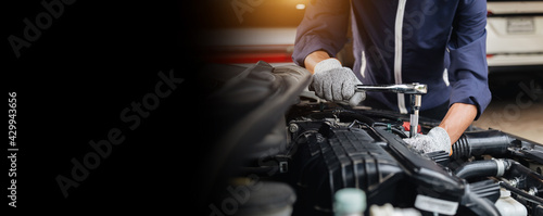 Automobile mechanic repairman hands repairing a car engine automotive workshop with a wrench, car service and maintenance,Repair service. photo