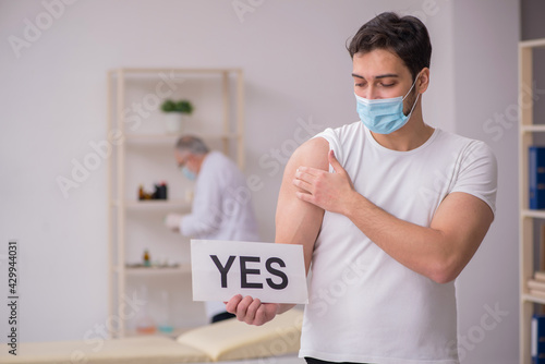 Young male patient visiting old male doctor in vaccination conce photo