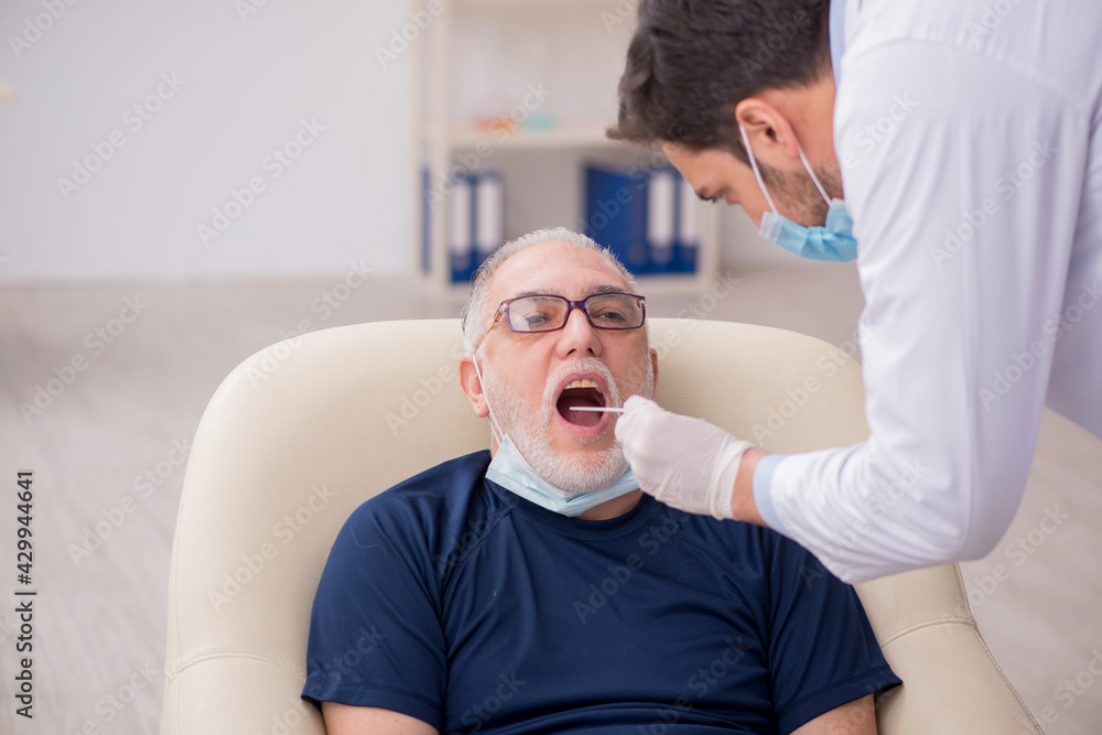 Old male patient visiting young male doctor otorhinolaryngologis Old male patient visiting young male doctor otorhinolaryngologis