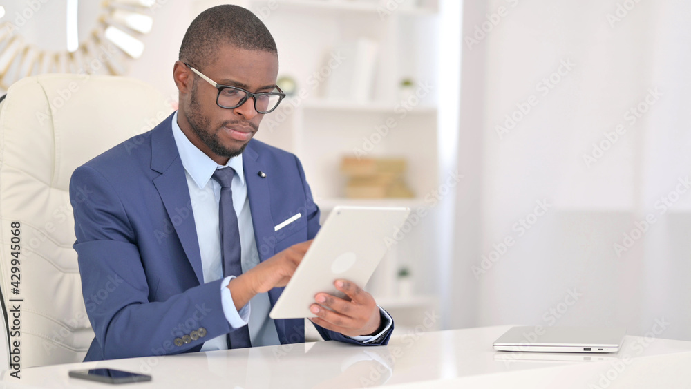 Professional Young African Businessman using Tablet in Office 