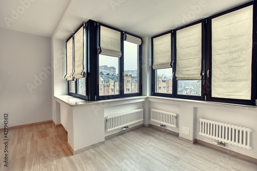 Empty white room interior with roman vertical curtains and parquet floor photo