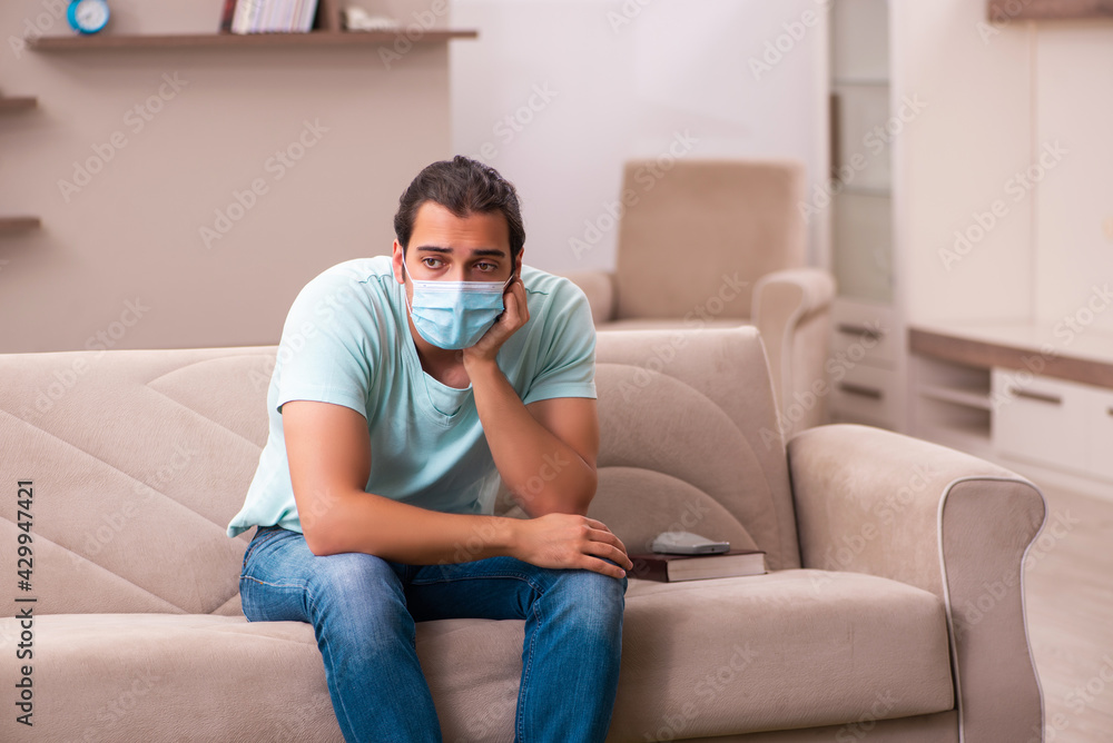 Obraz premium Young man sitting at home during pandemic