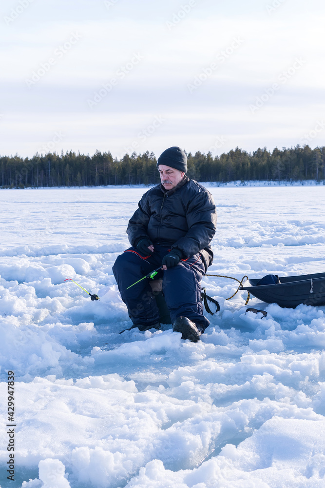 ice fishing. fisherman fishing on frozen lake. Winter frosty morning fishing on river. Vertical photo ice fishing. fisherman fishing on frozen lake. Winter frosty morning fishing on river. Vertical photo