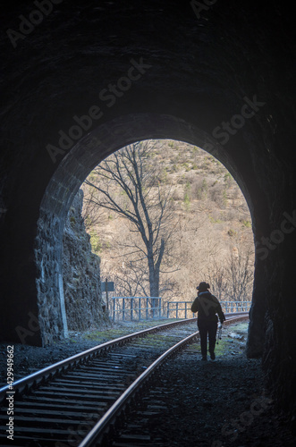 Man coming out of a dark railway tunnel