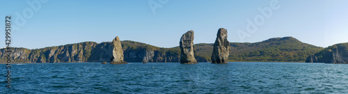 Exit on a yacht to the Avacha Bay of the Pacific Ocean. Panorama view of the rocks three brothers are a symbol of Avacha Bay and the city of Petropavlovsk-Kamchatsky. Kamchatka Peninsula, Russia.