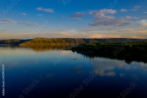 aerial view of fisherman at the boat on golden sunset river. silhouette of fishermen with his boat  Fisherman life style