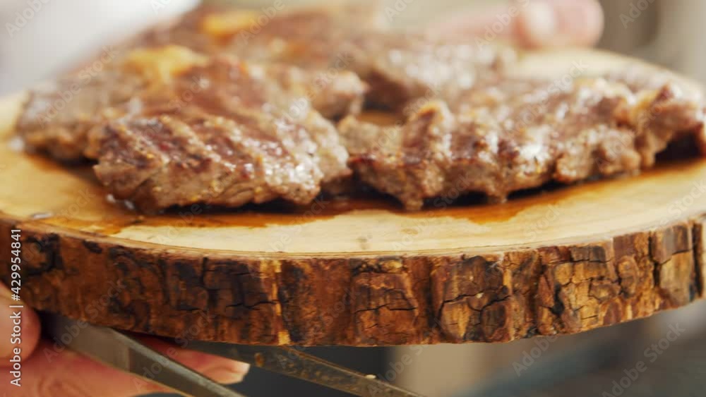 Young chef preparing grilled meat steak in a modern kitchen. The man prepares food at home. Cooking healthy food. Young chef preparing grilled meat steak in a modern kitchen. The man prepares food at home. Cooking healthy food.