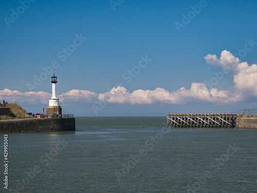 The entrance to Maryport Harbour on the Solway Coast in north west Cumbria, England, UK. On the left is the oldest cast iron lighthouse in the UK, which is a Grade II Listed building.
