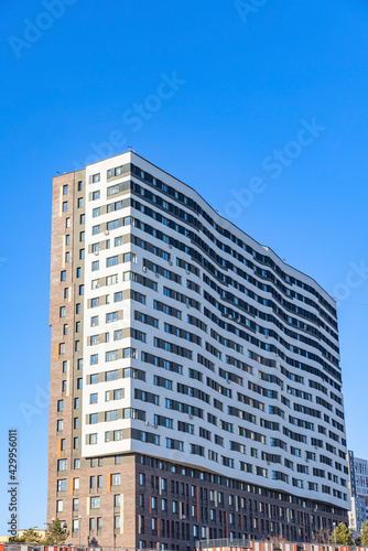 Modern residential apartment building on blue sky  © Aguus