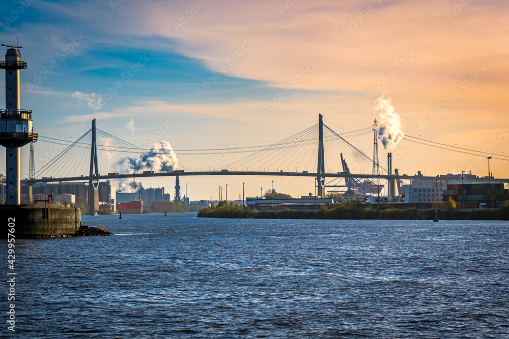 sight over port of hamburg industrial area with hamburgs most famous suspension bridge called Kohlbrand bridge, crossing the elbe river during dusk