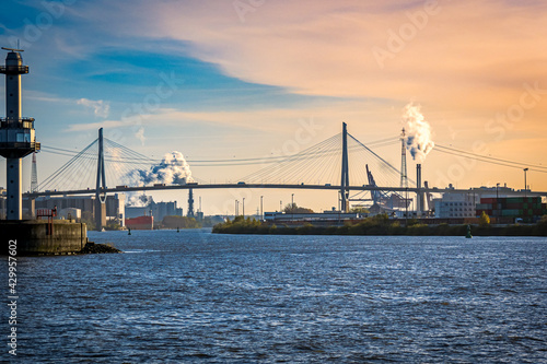 sight over port of hamburg industrial area with hamburgs most famous suspension bridge called Kohlbrand bridge, crossing the elbe river during dusk
