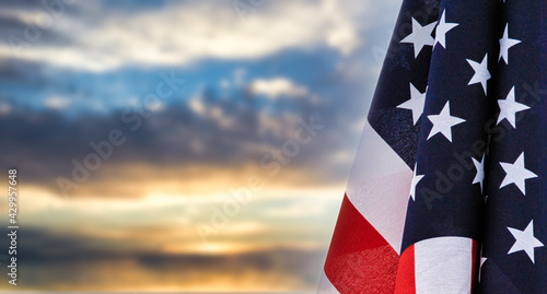 Patriotic United States of America flag at rest before a beautiful sky with room for text and cropping. Social media or web banner or header. 
