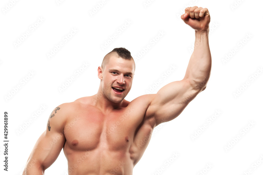 Happy bodybuilder enjoying victory. Smiling shirtless excited muscular healthy young man in good shape with hand in fist. White background, studio shot. Happy bodybuilder enjoying victory. Smiling shirtless excited muscular healthy young man in good shape with hand in fist. White background, studio shot.