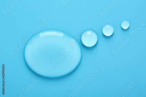Water drops in shape of Thought bubble on blue background. Transparent liquid speech balloon. Place for text.