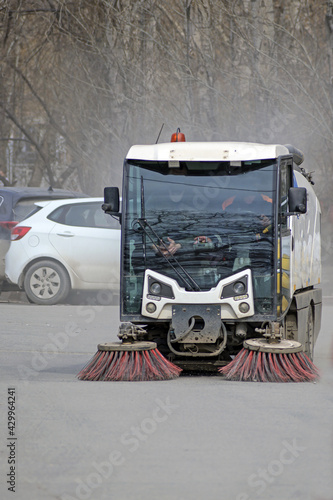 Canvastavla A utility car cleans the dirt from the parking lot