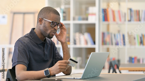 African Man having Online Payment Failure on Laptop in Library