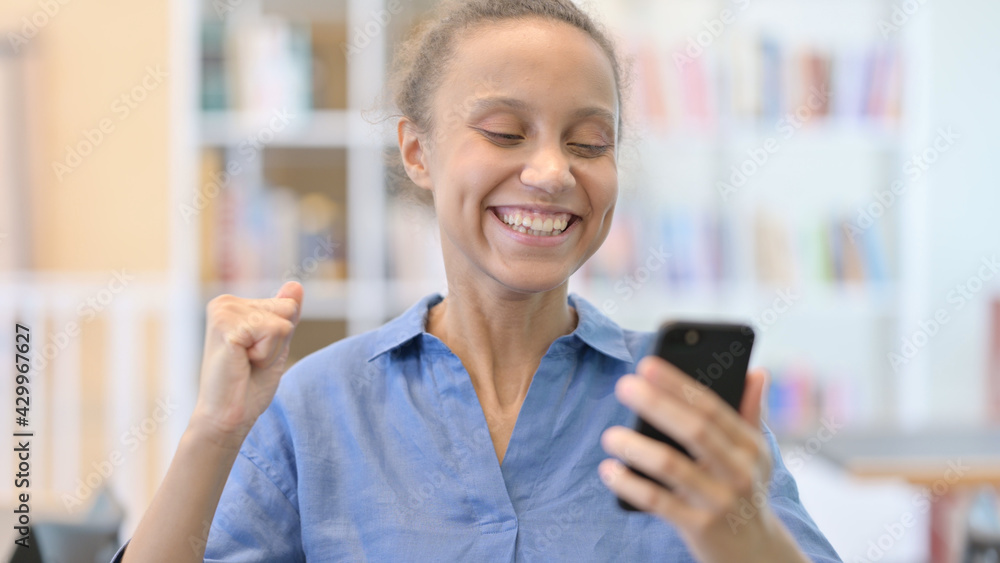 Portrait of African Woman Celebrating Success on Smartphone Portrait of African Woman Celebrating Success on Smartphone