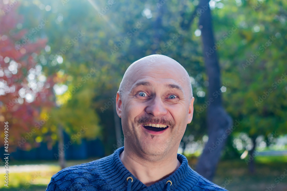 Portrait of a surprised bald man in a blue sweater Portrait of a surprised bald man in a blue sweater