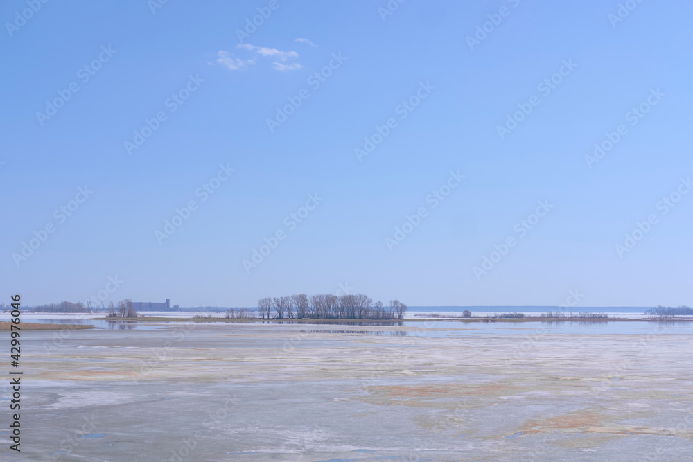 Winter panorama of the frozen Volga against the background of the blue sky and clouds in the bright rays of daylight.