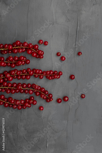 Red currants on gray concrete background. Gray stone background. Top view.