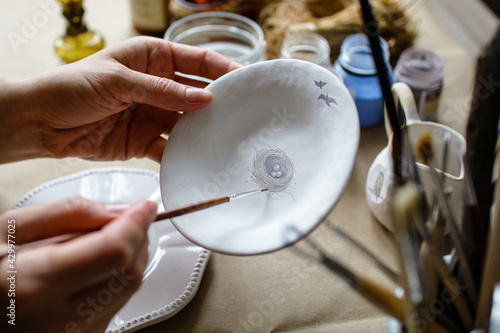 Hand-painting homemade ceramic dishes.