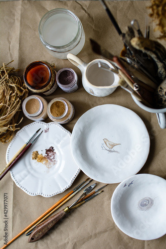 Hand-painting homemade ceramic dishes.