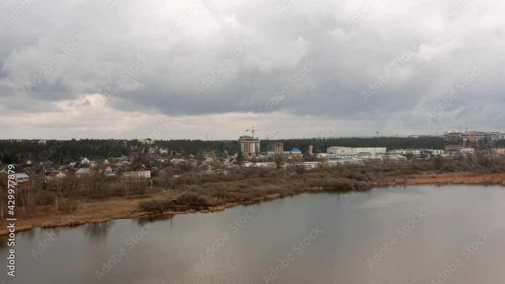 Aerial wide view of cityscape with coastline on a cloudy day. Drone shot of urban background. Aerial wide view of cityscape with coastline on a cloudy day. Drone shot of urban background.