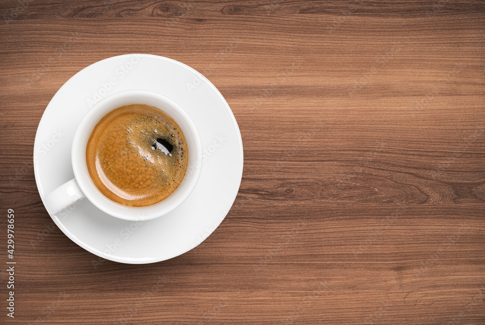 Fototapeta premium Top view of Hot Coffee in white cup and plate on beautiful wooden table.