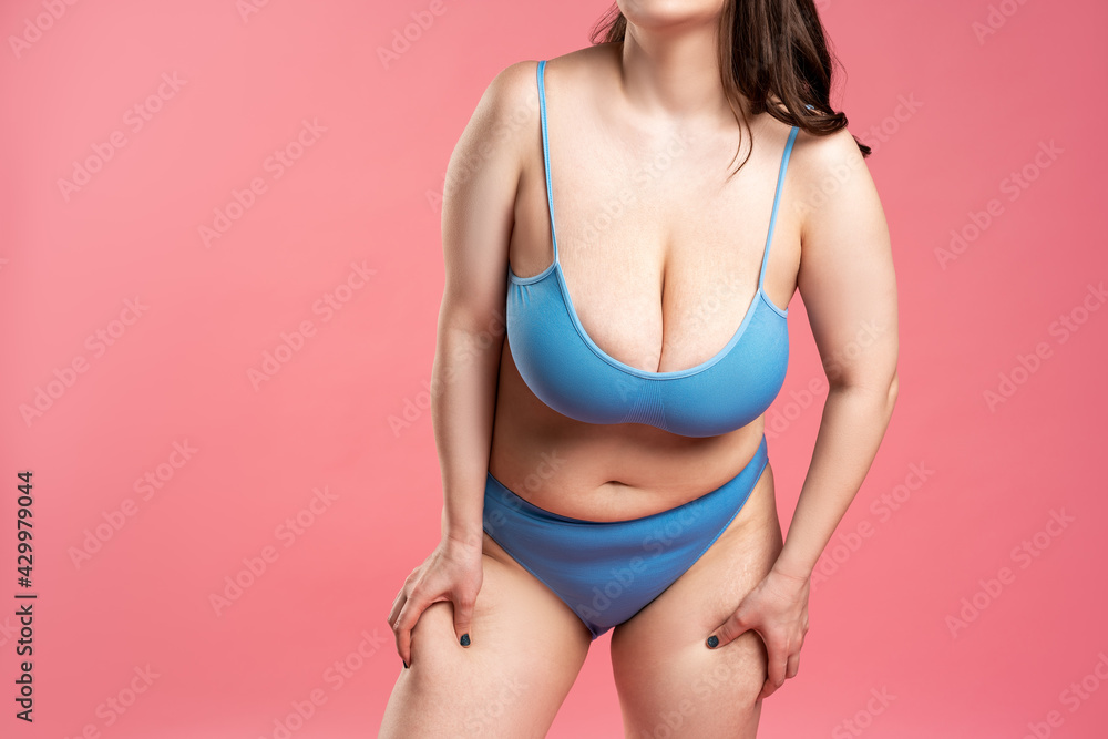Foto de Fat woman with very large breasts in blue underwear on pink  background, body care concept do Stock